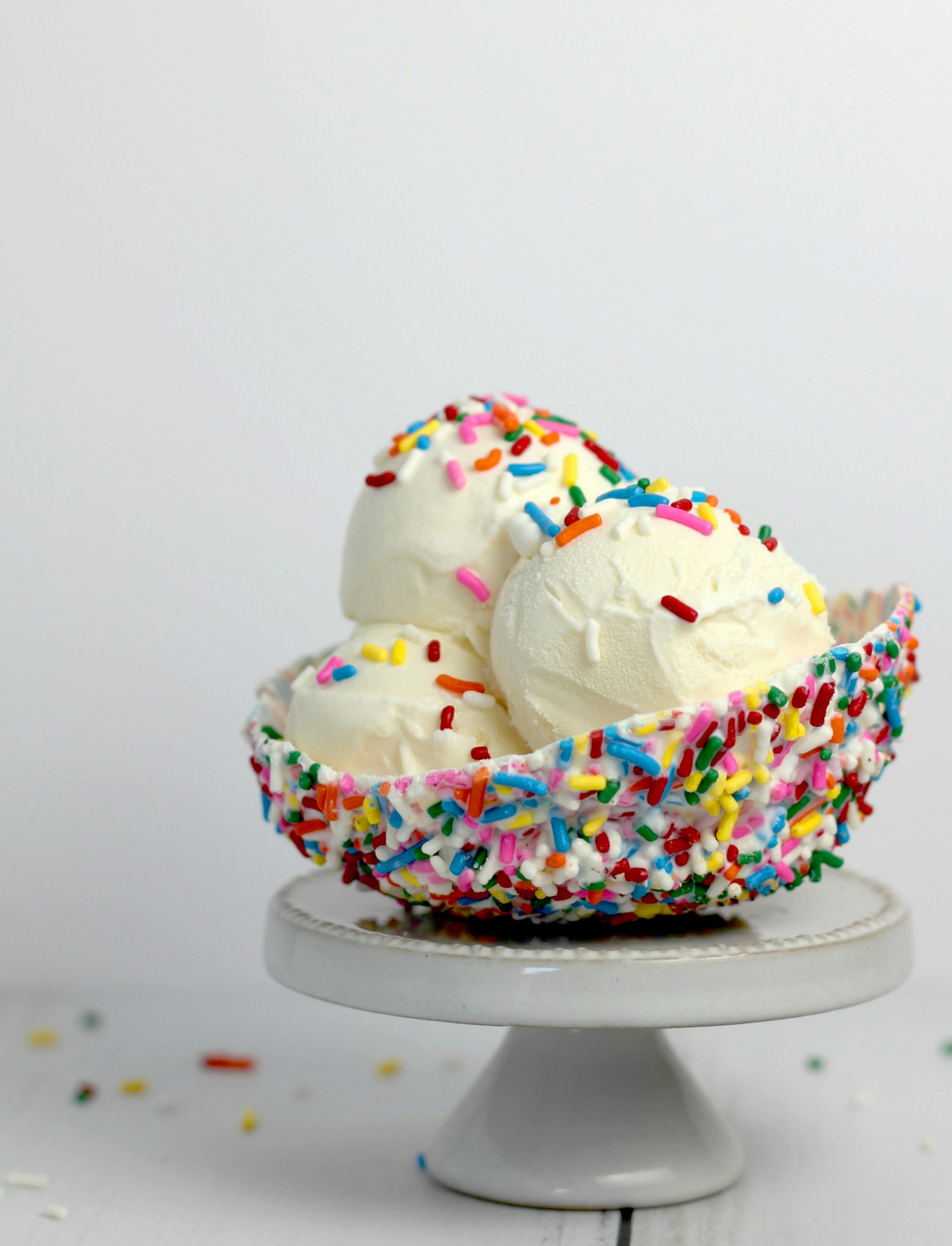 Scoops of ice cream on a sprinkle-rimmed stand