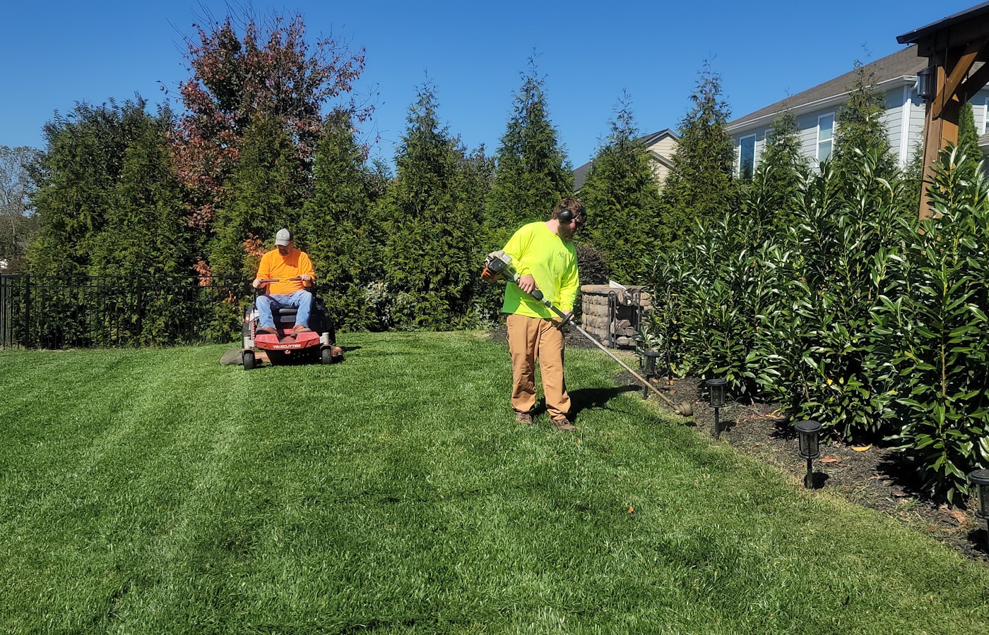 Crew mowing a large residential lawn